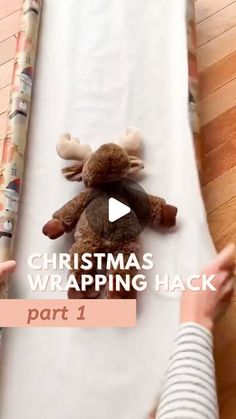 a person is holding a stuffed animal on a sheet with the words christmas wrapping hack