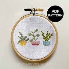 a cross stitch pattern with three potted plants