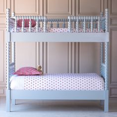 a white bunk bed with polka dot bedspread