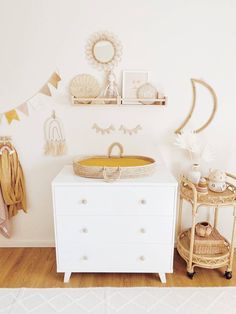 a white dresser sitting next to a baby crib