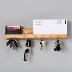 a wooden shelf with keys and a card holder