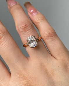 a woman's hand with an engagement ring on it and a diamond in the middle