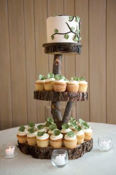 a three tiered cake with cupcakes on the bottom and green leaves on top