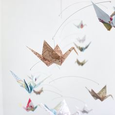 several origami cranes are flying in the sky