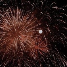 fireworks are lit up in the night sky with bright red and white lights on them