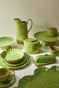 a table topped with green dishes and plates