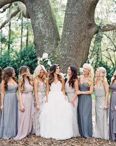 a group of women standing next to each other in front of a tree