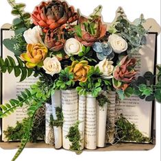 an arrangement of flowers in vases sitting on top of books