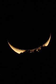 the moon is seen in the dark sky