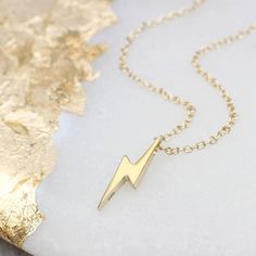 PRODUCT DESCRIPTION * David Bowie 'Ziggy Stardust' inspired lightning bolt floating necklace in yellow gold vermeil. * Add personalisation with a discreet tag to the back of the necklace. * Matching earrings available. * Also available in rose gold vermeil and sterling silver. PERSONALISATION * We engrave our pieces to create bespoke items especially for you, we are always happy to try and help if something is unsuitable but we regret we are unable to offer refunds on personalised items. FREE GI Gold Lightning Bolt Jewelry Gift, Gold Lightning Bolt Jewelry For Gift, Lightning Necklace, David Bowie Ziggy Stardust, Lightning Bolt Necklace, Personalized Gold Necklace, Unusual Necklace, Necklace Matching, Floating Necklace