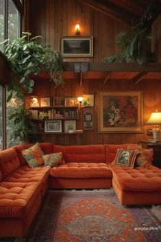 a living room with orange couches and potted plants