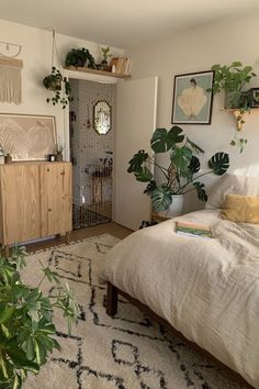 a bed room with a neatly made bed and plants