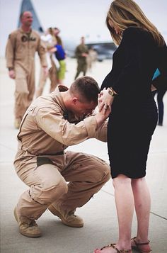 a man kneeling down next to a woman