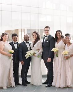 a group of people standing next to each other in front of a tall glass building