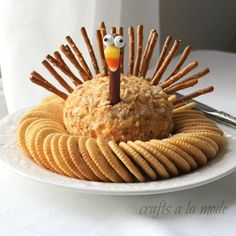 a white plate topped with crackers and a turkey made out of crackers on top of it