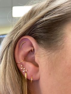 a close up of a person with ear piercings on their ears and behind them is a woman's head