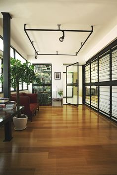 an empty room with wooden floors and lots of windows on the side of the wall