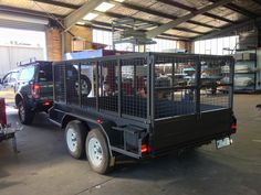 a truck with caged animals in it's bed is parked in a warehouse