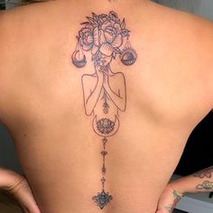 the back of a woman's body with flowers on it and a tatoo