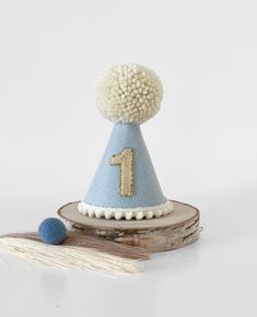 a blue and white party hat sitting on top of a piece of wood