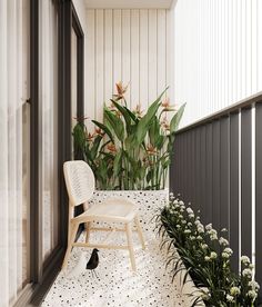 a white chair sitting on top of a balcony next to flowers