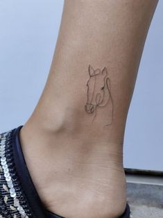 a woman's foot with a small horse tattoo on the left side of her ankle