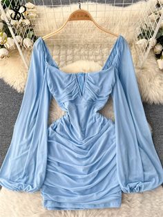 a blue dress on a hanger in front of a white furnishing area