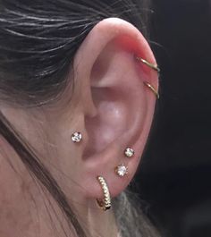 a close up of a person's ear with three different types of piercings