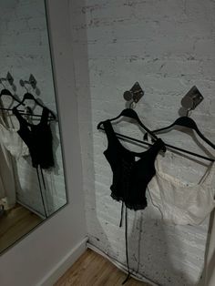 three bras are hanging on the wall in front of a mirror, and there is no image here to provide a caption for