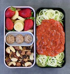 two trays filled with pasta, fruit and nuts next to each other on a table