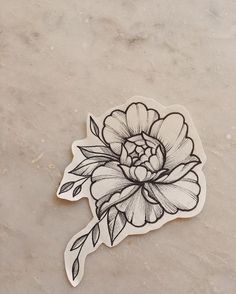 a black and white flower sticker sitting on top of a marble countertop next to a tile floor