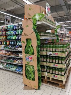 a display in a grocery store filled with lots of green stuff and drinks for sale