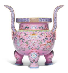 a pink vase with an elaborate design on the top and bottom, sitting in front of a white background