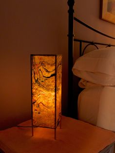 a lamp sitting on top of a table next to a bed