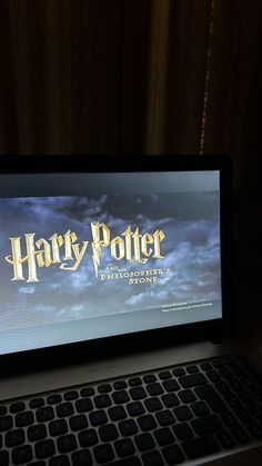 a laptop computer sitting on top of a desk next to a window with the harry potter logo