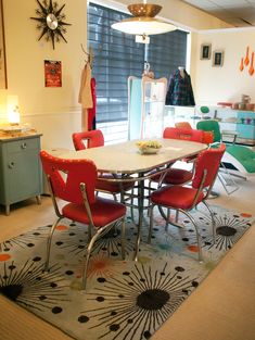 a dining room filled with lots of colorful furniture and decor on top of a rug