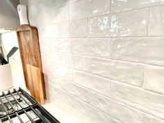 a stove top oven sitting next to a wooden cutting board