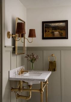 a white sink sitting under a bathroom mirror next to a wall mounted faucet