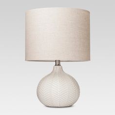 a white table lamp with a beige shade