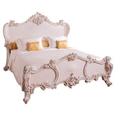 an ornate white bed with gold pillows on it's headboard and foot board