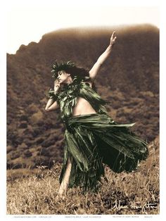 a woman in a green dress standing on top of a grass covered hill with her arms outstretched