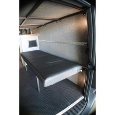 the inside of a van with a table and microwave in it's back door