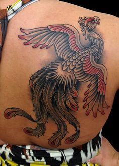 the back of a woman's body with a bird tattoo on her upper half