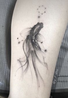 a black and white photo of a goldfish tattoo on the right arm, with bubbles coming out of it