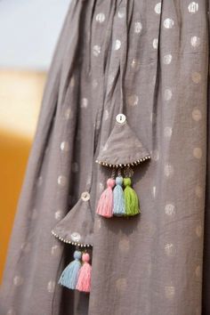 three tassels are attached to the back of a dress with polka dots on it