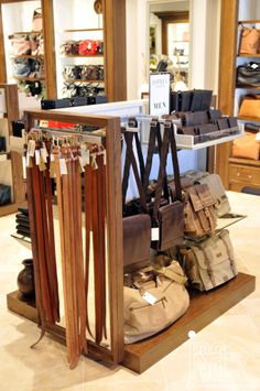 an assortment of items displayed on display in a clothing store, including boots and purses