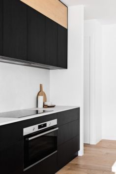 an empty kitchen with black cabinets and white counter tops