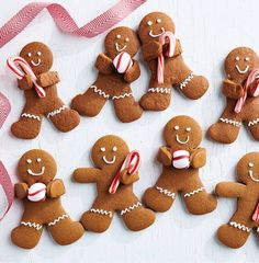 several gingerbreads with candy canes and candies on them are arranged in the shape of people