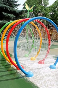 colorful water sprinkles are being used to play in an outdoor playground area