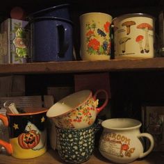 many different types of mugs are on the shelf